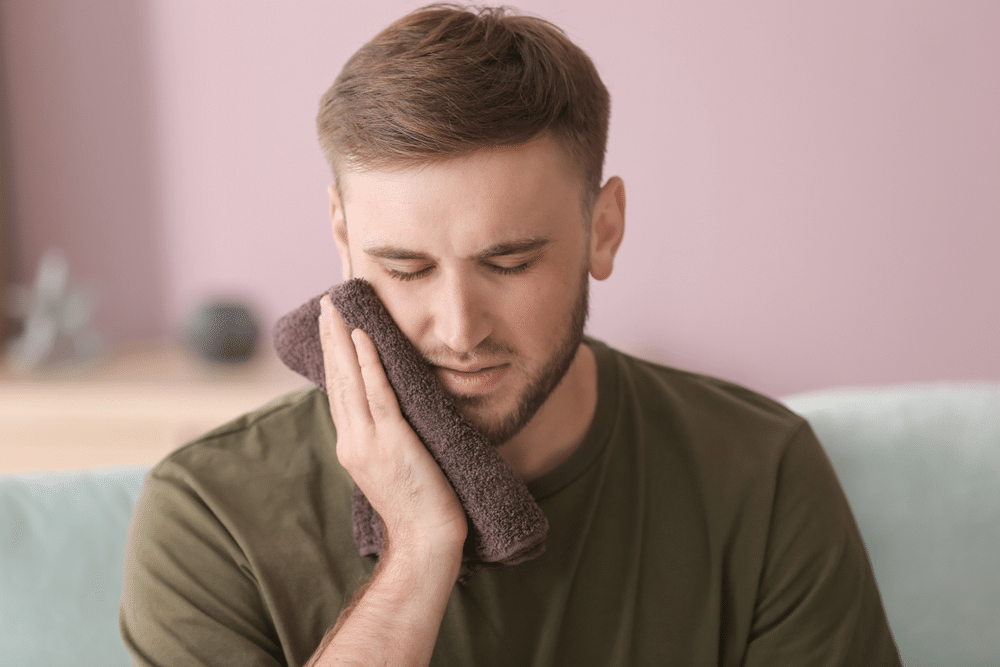 the man pressed his face with cold towel