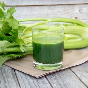 Celery leaves and a glass of juice